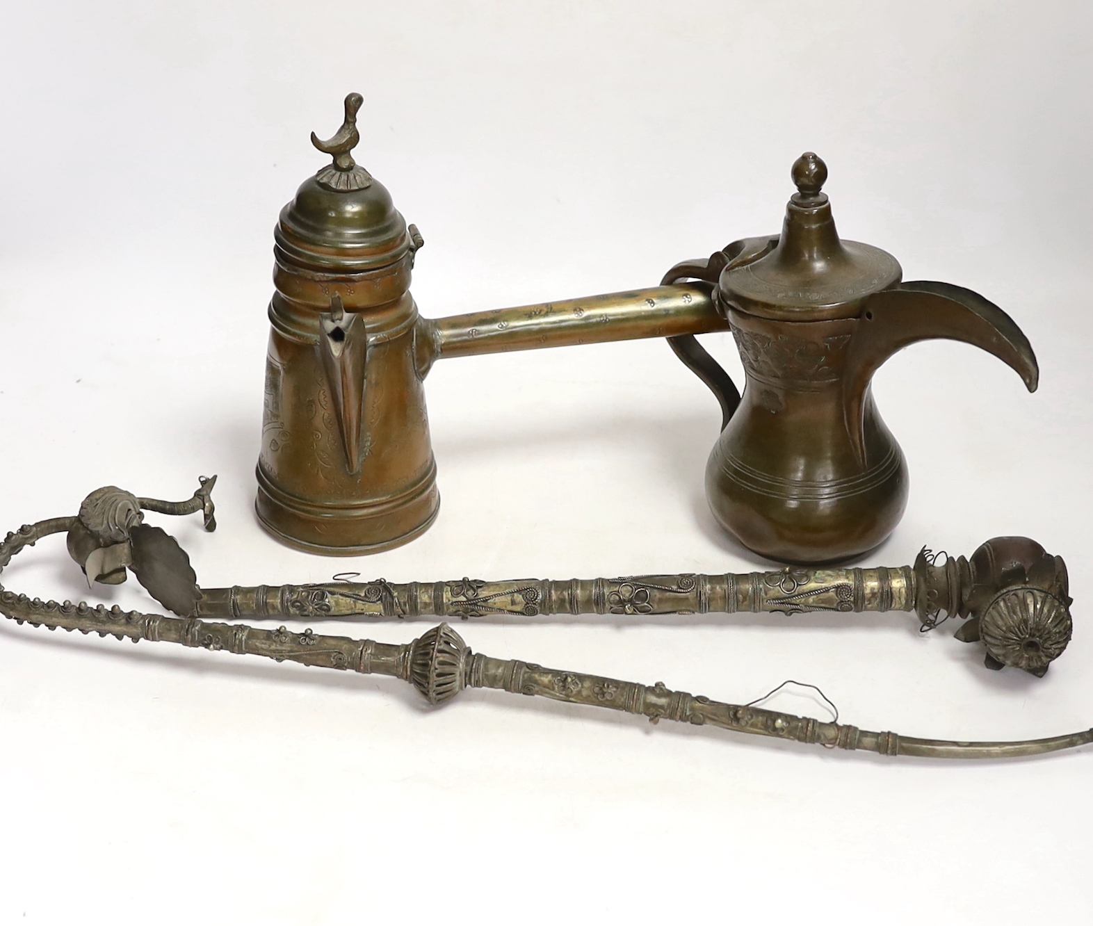Two Indian opium pipes and two Dallah coffee pots, tallest pot 22cm